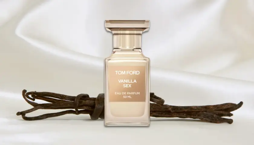 Flakon perfum Tom Ford Vanilla Sex na tle jedwabiu, obok lasek wanilii.