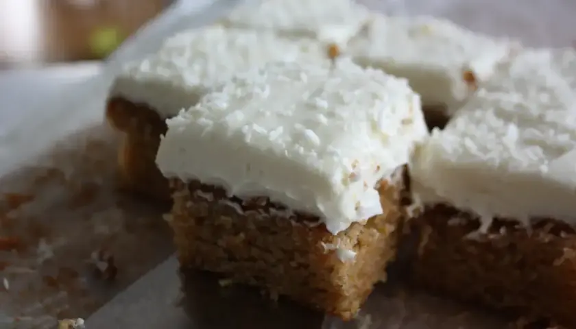 Små fyrkantiga kakor med vit frosting och kokosflingor. Kanske en hint av lime curd i smaken?