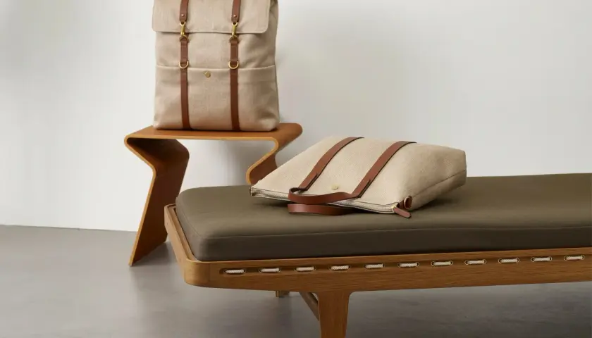 Plecak i torba Pieces, wykonane z płótna i skóry, prezentują się elegancko na meblach.