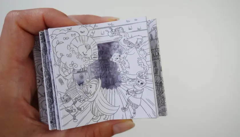 Un libro desplegable con dibujos de manualidades del Mago de Oz, mostrando al León, el Espantapájaros y Dorothy.