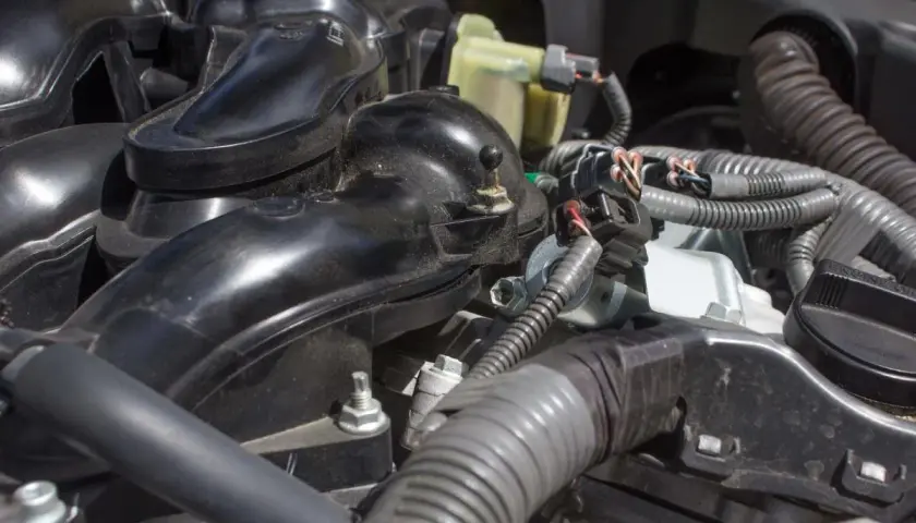 Detailaufnahme des Motors eines VW p0172. Schwarze Kunststoffteile und Kabelstränge sind sichtbar.