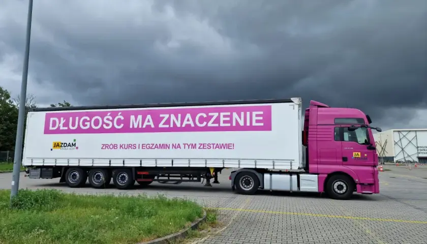 Różowy ciągnik z naczepą, na której widnieje napis "DŁUGOŚĆ MA ZNACZENIE". Idealny do nauki manewrów z dopuszczalną masą całkowitą zespołu pojazdów c+e.