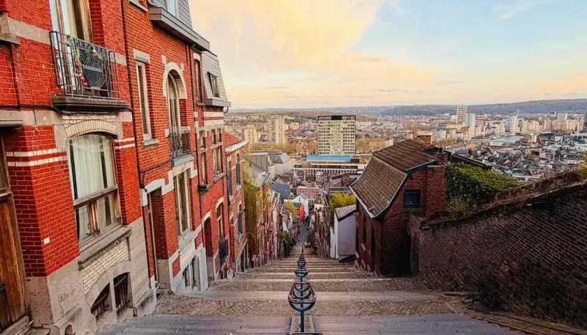 Treppen hinunter in eine Stadt in Belgien. Erkunden Sie die charmanten Gassen und genießen Sie die Aussicht – so kann man in Belgien machen!