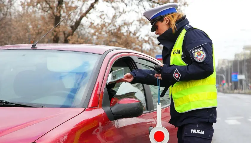 Policjantka kontroluje dokumenty kierowcy. Warto mieć przy sobie dowód rejestracyjny, by uniknąć problemów.