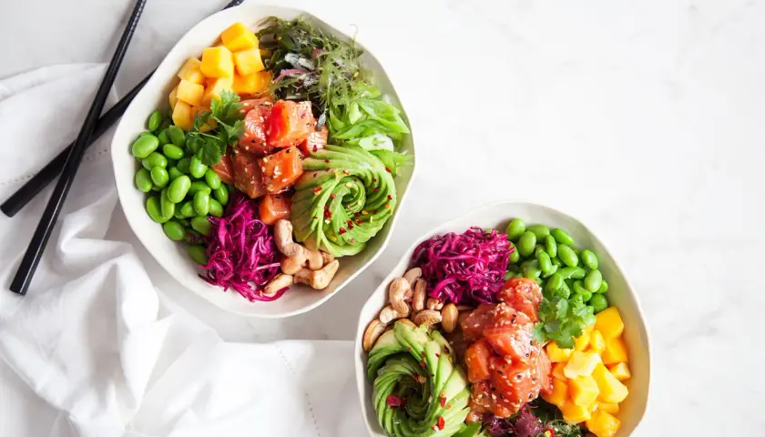 Två färgglada bowls med lax, avokado, mango, edamame och rödkål. Perfekt för en hälsosam lunch eller middag, inspirerade av bowls recept.