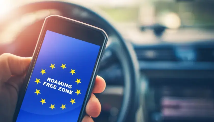 Telefon z flagą UE i napisem "ROAMING FREE ZONE". Podróżując po UE, nie trzeba włączać roamingu.