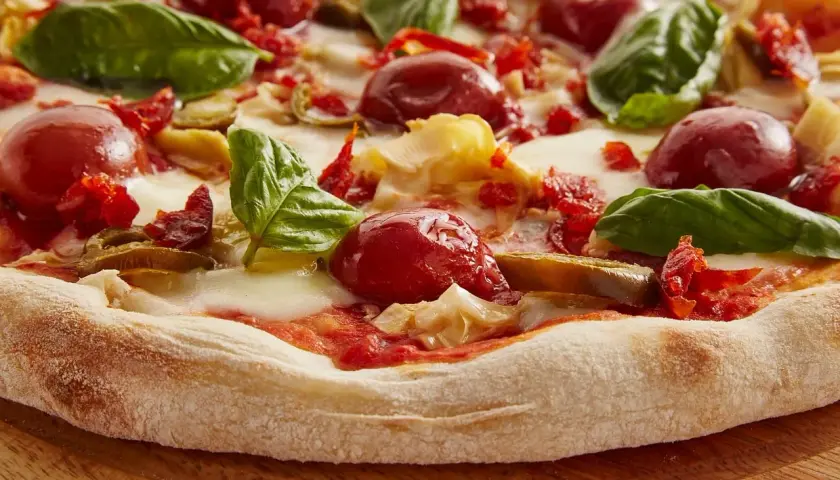 Pyszna pizza z pomidorkami, bazylią i ciągnącym się **serem mozzarella**. Idealna na letni wieczór.