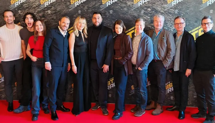 Rollistan i ett sista race samlad på röda mattan. Skådespelare och regissör poserar framför en bakgrund med filmens logotyp.