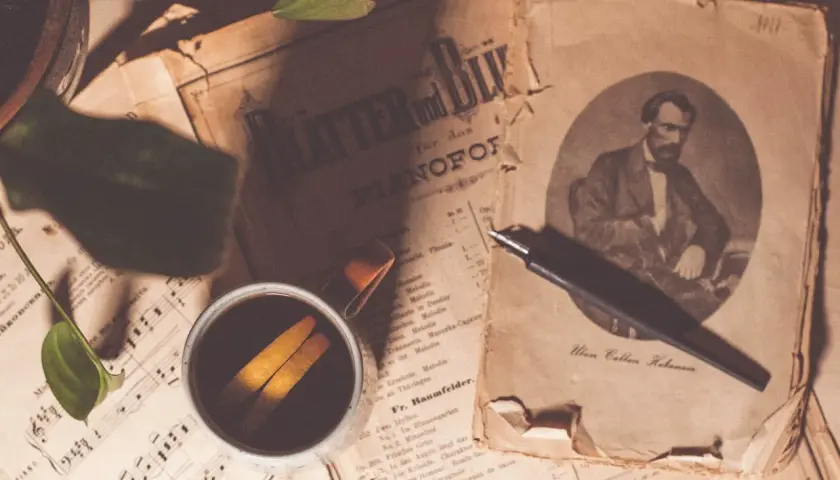 Sepia fotografia. Stare nuty, filiżanka kawy z pomarańczą i pióro.