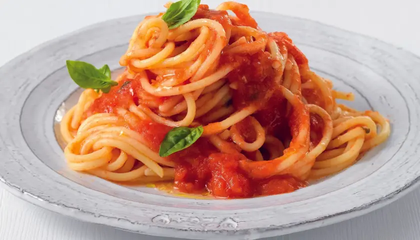 Un piatto di pasta con pomodorini freschi e basilico, un classico della cucina italiana.