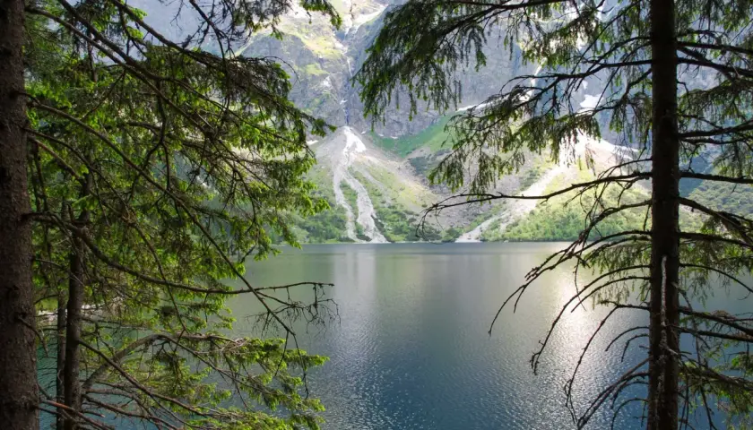 Widok na Morskie Oko, gdzie góry odbijają się w tafli wody. To miejsce, gdzie rodzi się legenda o morskim oku.