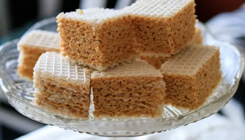 Słodkie wafle przekładane masą z mleka w proszku, ułożone na szklanej paterze.