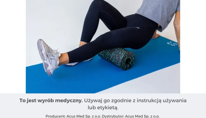 Kobieta wykonuje rolowanie przywodzicieli na macie z użyciem czarnego rollera z zielonymi kropkami.