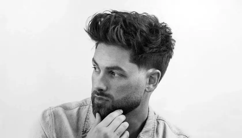 Dos cortes de pelo masculinos: un taper fade con diseño y un fade más pronunciado.