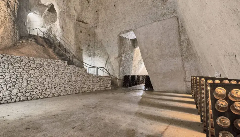 Visite cave Ruinart : avis sur ces crayères historiques où le champagne vieillit. Bouteilles en pupitres, escaliers de pierre.