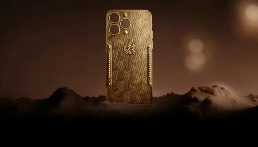Złoty telefon z wytłoczonym wzorem, przypominający największy telefon na świecie, stoi na tle marsjańskiego krajobrazu.