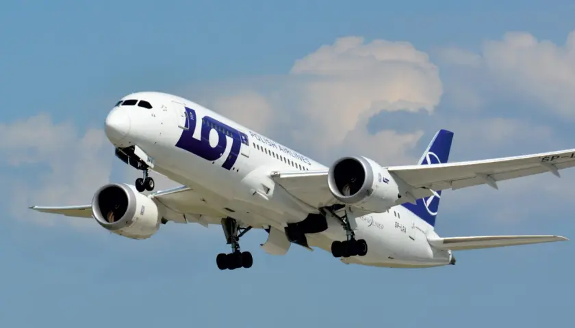 Boeing 787-8 Dreamliner LOT, z widocznym logo i napisem "POLISH AIRLINES". Samolot wznosi się na tle błękitnego nieba z chmurami.