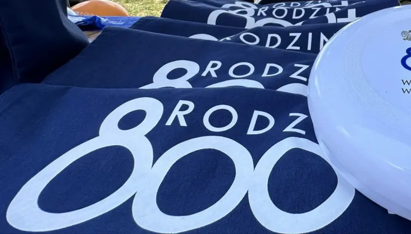 Granatowe koszulki z napisem "RODZINA 800 plus" i biały frisbee z logo 800 plus.