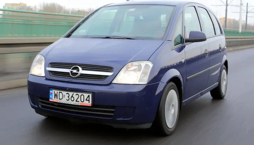 Niebieski Opel Meriva A jedzie po moście.
