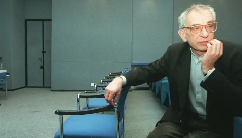 Krzysztof Kieślowski, reżyser znany z głębokich filmów, siedzi w pustej sali.