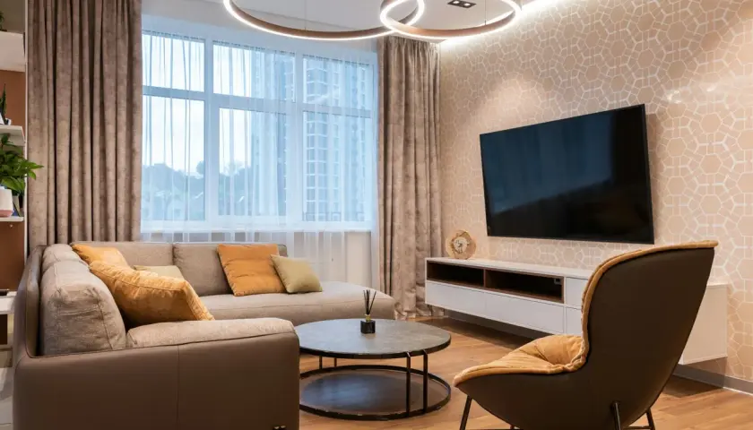 Salon moderne avec canapé, fauteuil, table basse et TV. Le **plan éclairage** met en valeur les suspensions circulaires et l'applique murale.