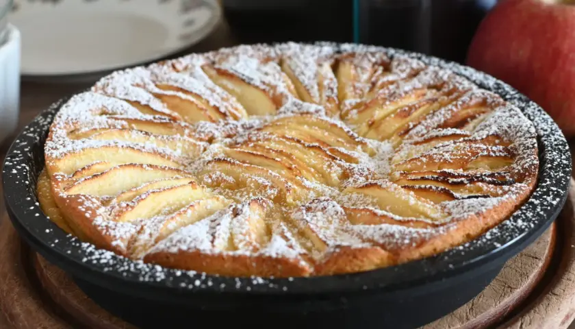 Torta di mele in friggitrice ad aria, dorata e cosparsa di zucchero a velo, pronta per essere gustata.