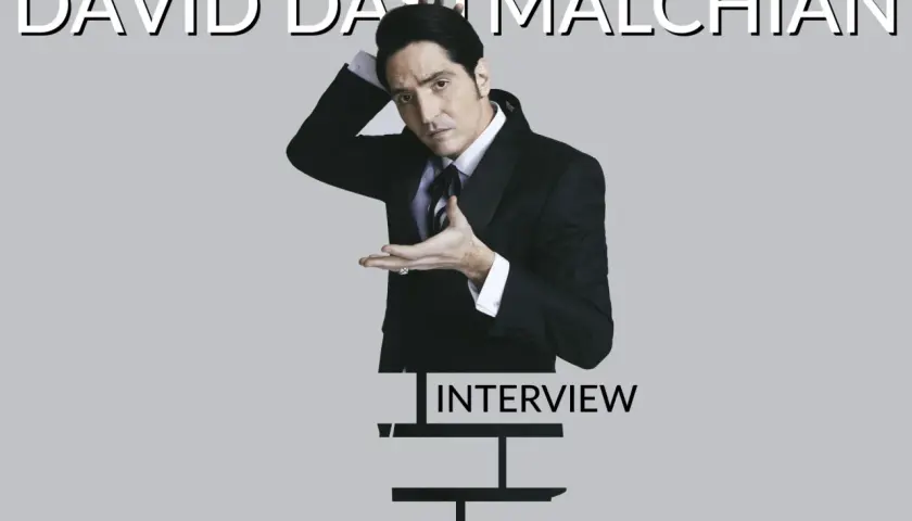 David Dastmalchian in un completo elegante, pronto per un'intervista.