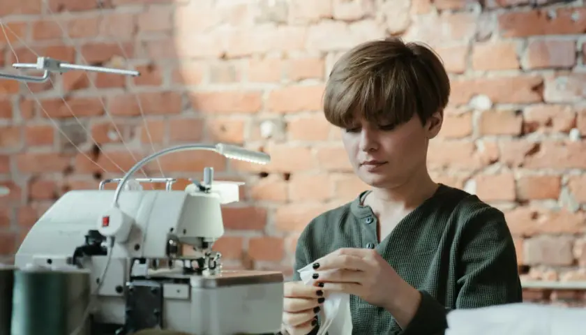Krawcowa przygotowuje materiał, by pokazać, jak wszyć klin do spodni w kroku.