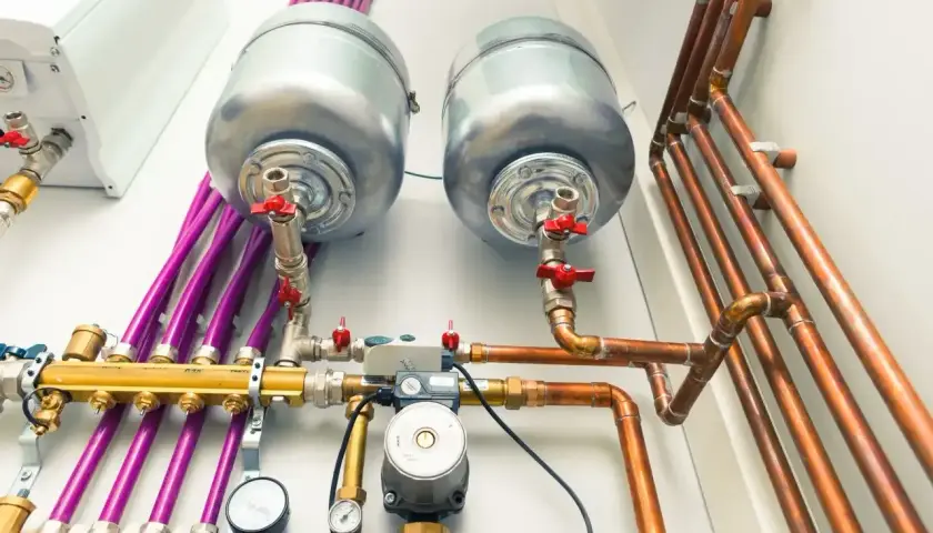 Nowoczesna instalacja gazowa w domu z dwoma zasobnikami, pompą obiegową i miedzianymi rurami.
