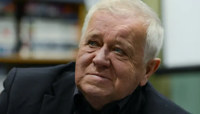 Marian Dziędziel, znany z wielu niezapomnianych ról w polskich filmach, zamyślony w czarnym garniturze.