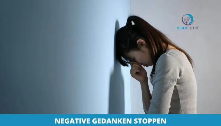 Verzweifelte Frau lehnt an Wand. Beispiele, wie man negative Gedanken in positive umwandeln kann, helfen ihr, wieder Hoffnung zu schöpfen.