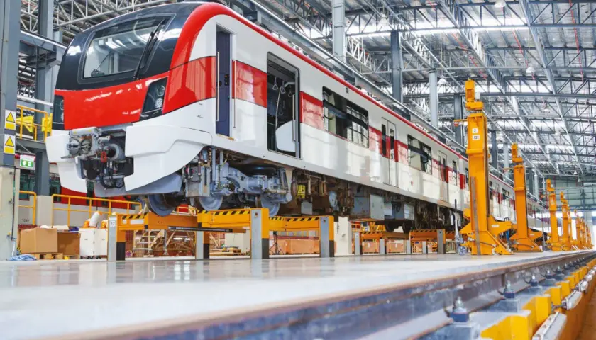 Nowy pociąg w hali produkcyjnej, gotowy do montażu napędu pojazdów szynowych.