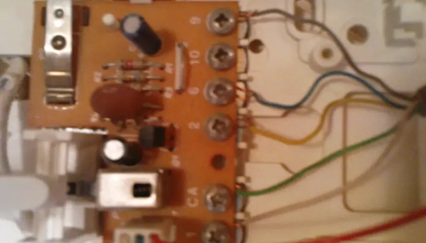 Wnętrze unifonu z widoczną płytką drukowaną, elementami elektronicznymi i przewodami.