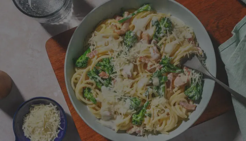 Ein Teller Spaghetti Carbonara, original italienisch, mit Brokkoli und Speck, bestreut mit Parmesan.