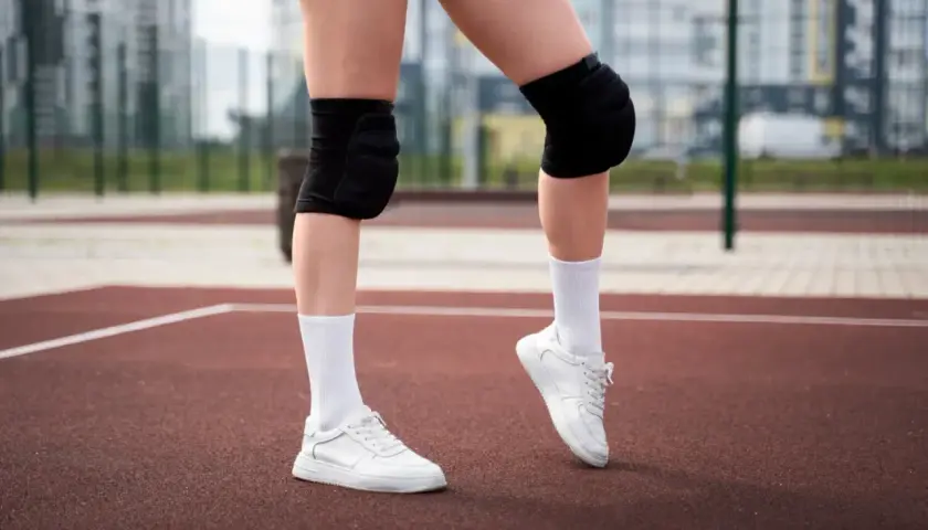 Gotowe do gry! Białe skarpetki siatkarskie, ochraniacze na kolana i sportowe buty to podstawa.
