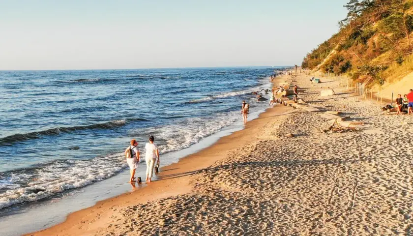 Spacer po plaży, idealne miejsce, gdzie jechać nad morze w listopadzie. Spokojne fale, piaszczysty brzeg i łagodne słońce.