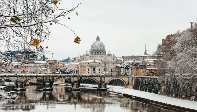 Roma innevata: la cupola di San Pietro e Ponte Sant'Angelo riflessi sul Tevere. Un raro freddo romano.