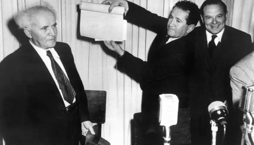 David Ben-Gurion hält ein Dokument hoch, das die Entstehung Israels symbolisiert.