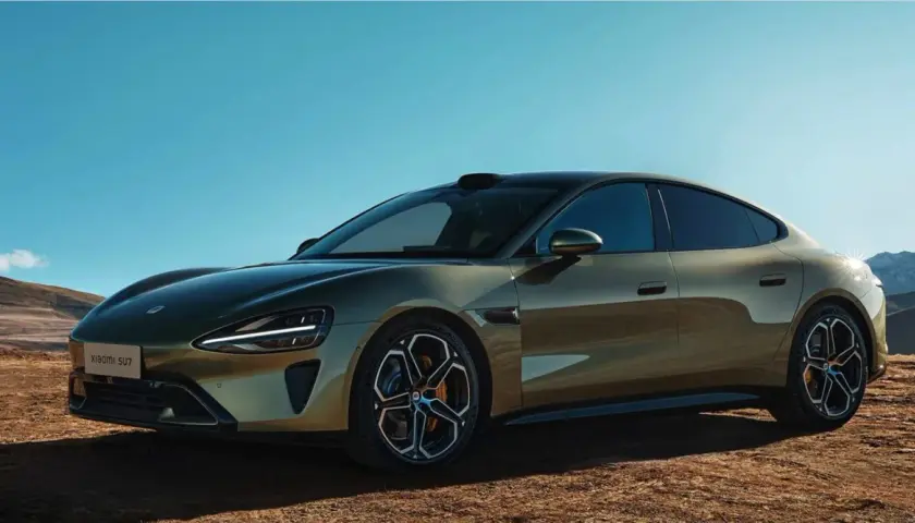 La nuova Xiaomi SU7, un'auto elettrica dal design audace, si presenta in un paesaggio desertico sotto un cielo azzurro.