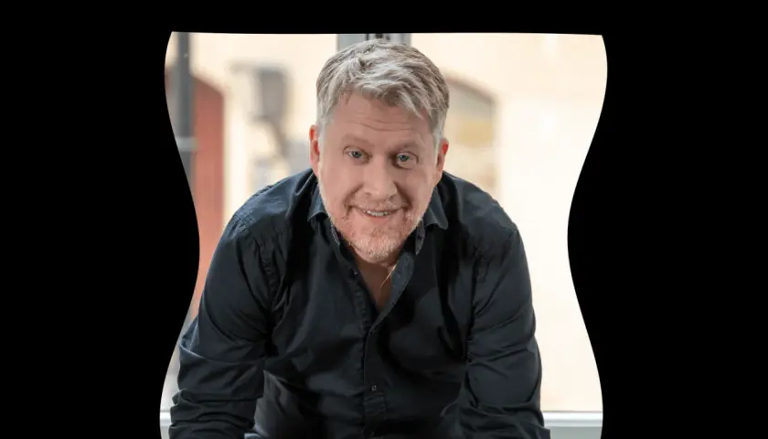 Jesper Ersgård ler mot kameran i en svart skjorta.