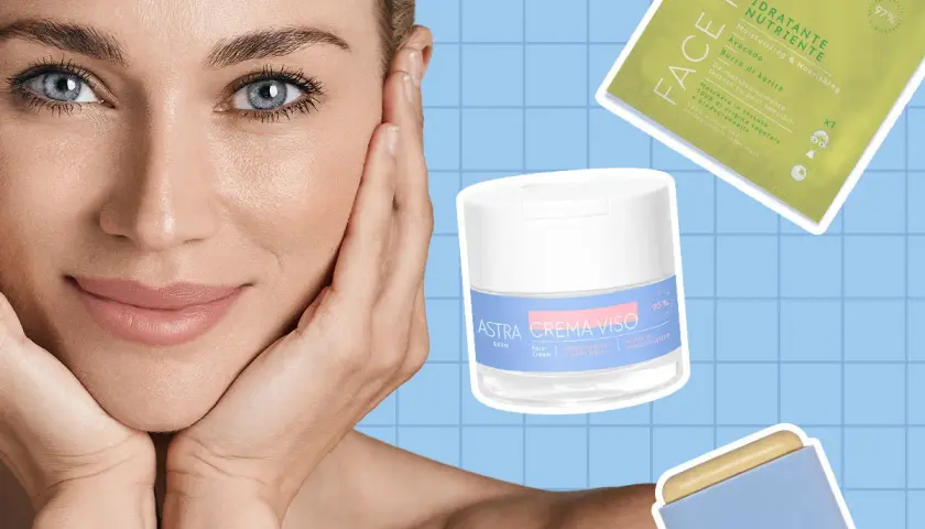 Donna con mani sul viso, circondata da prodotti Astra per la cura della pelle, per una skin longevity radiosa.