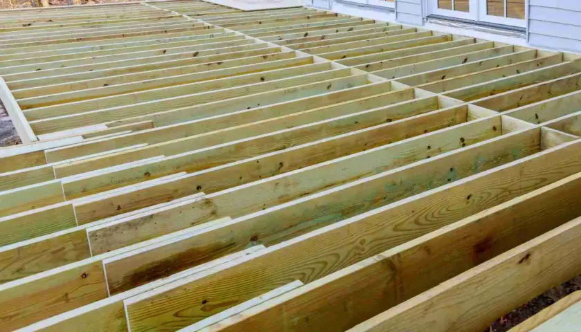 Structure en bois d'une terrasse en cours de construction, avec des solives de portée 63x175 espacées régulièrement.