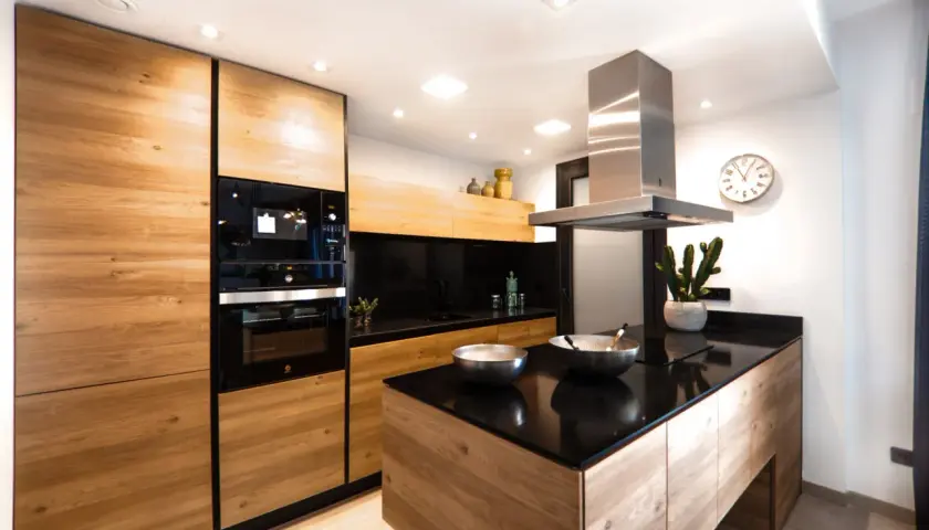 Cucina moderna con ante in legno di rovere, piano in quarzo nero e isola centrale. Un progetto per rinnovare cucina in legno con stile.