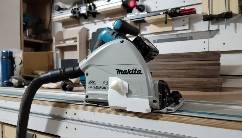 Sega circolare Makita su binario, pronta per tagliare profilo alluminio con precisione. Aspirazione collegata per un ambiente di lavoro pulito.