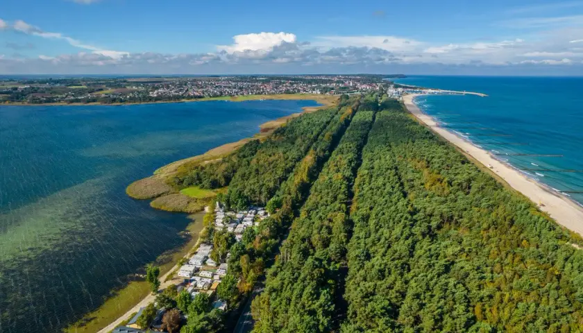 Półwysep Helski z lotu ptaka: las sosnowy, plaża, morze i zatoka. Widoczny kemping i zabudowania.