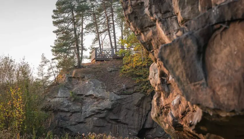 Kamienne miasto z platformą widokową wśród sosen. Skały tworzą naturalne miasto, a drewniana konstrukcja zaprasza do podziwiania krajobrazu.