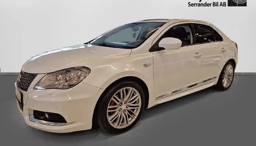 Vit Suzuki Kizashi, en elegant sedan med sportiga fälgar och kromdetaljer.