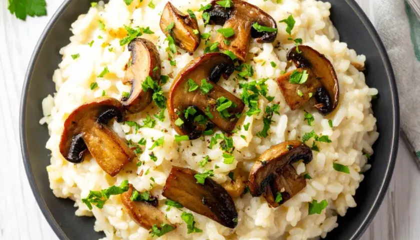 Un crémeux risotto aux cèpes, garni de champignons poêlés et de persil frais. Un plat réconfortant et savoureux.