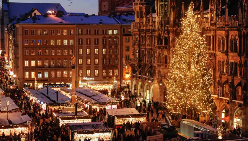 Ein belebter weihnachtsmarkt ostbahnhof mit einem riesigen, funkelnden Weihnachtsbaum und vielen Buden.