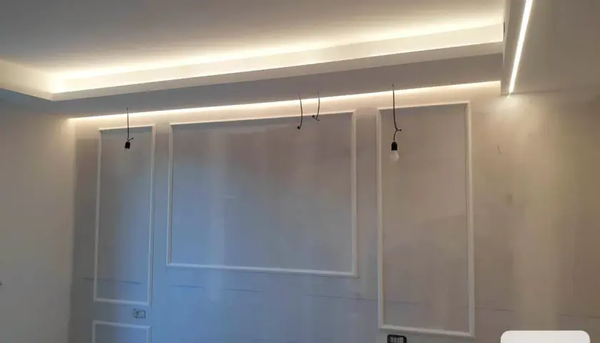 Soffitto in cartongesso con illuminazione a LED integrata e decorazioni a rilievo.
